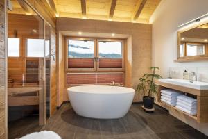 a bathroom with a large tub and a sink at Holzlodge Chalets Nähe Obertauern in Radstadt +40 photos