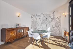 ランブイエにあるL'Arboré, maison d'architecte avec hammamのテーブルと白い椅子のあるダイニングルーム