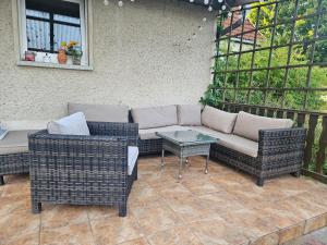 a patio with a couch and two chairs and a table at Ferienwohnung zu den Blauen Schafen in Rheinsberg