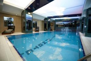 a large blue swimming pool in a hotel at Ilkbal Deluxe Hotel &Spa Istanbul in Istanbul