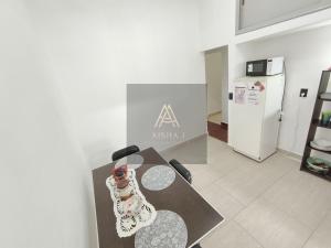 ein Raum mit einem Tisch und eine Küche mit einem Schild in der Unterkunft Aisha Alojamiento in Salta + 14 Fotos