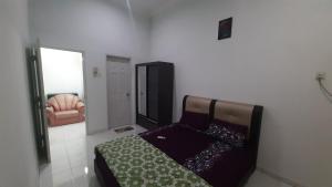 a bedroom with a bed and a chair in it at Glory Homestay Ipoh in Ipoh