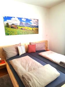 a bedroom with two beds and a painting on the wall at Peter Paul Domblick Erdgeschoss in Appiano sulla Strada del Vino