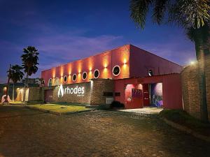 a red building with lights on the side of it at Rhodes Motel Recife in Recife