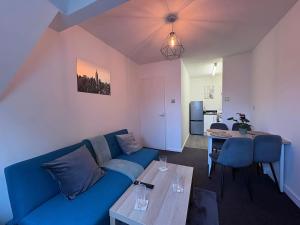 a living room with a blue couch and a table at Central One-Bedroom Flat - Free Private Parking in Chesterton