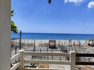 a view of a beach with a fence and the ocean at Calishores Beachfront Resort in Morong