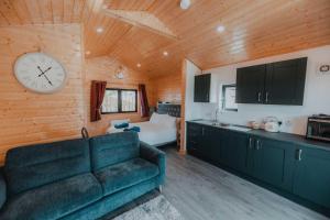 a living room with a couch and a clock on the wall at Benone Retreat in Castlerock