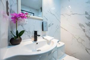 une salle de bain avec un lavabo et une fleur dans un vase dans l'établissement OceanFront Larcomar Apartments, à Lima 68 autres photos