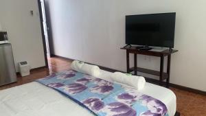 Habitación con TV y cama con manta. en Villa Prada Familiar, en Quepos