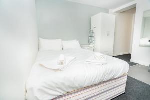 a bedroom with a white bed with towels on it at Compact & Cosy Central Coventry Budget Studio in Coventry +24 photos
