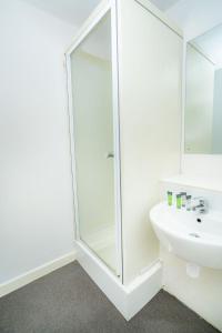 a white bathroom with a shower and a sink at Compact & Cosy Central Coventry Budget Studio in Coventry