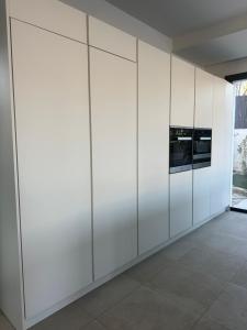 een kamer met witte kasten en een magnetron bij Villa Clara chambre double in La Ciotat