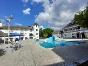 a swimming pool in front of a large building at Beach Studio 27 in Ocho Rios