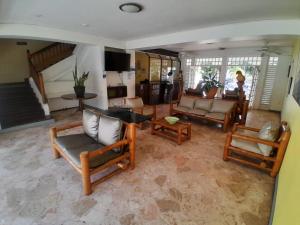 a living room with couches and chairs and a staircase at Beach Studio 27 in Ocho Rios