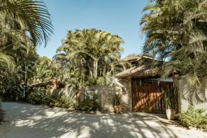 a house on the beach with palm trees at Espaço CurAmar - Praia de Itamambuca in Ubatuba