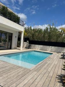 een zwembad op een houten terras naast een huis bij Villa Clara chambre double in La Ciotat