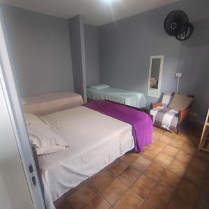 a small bedroom with a bed and a chair at Suite confortável no centro com Wi fi e TV a Cabo in Águas de São Pedro