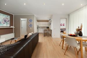 a living room with a black leather couch and a table at Apartments Casa Emonia in Novigrad Istria
