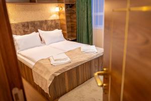 a bed in a room with two towels on it at SION Boutique Guest rooms in Veliko Tŭrnovo