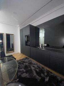 a living room with a glass table and a kitchen at LY Studio Pipera in Voluntari