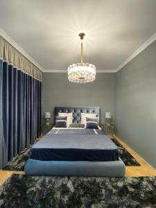 a bedroom with a large bed and a chandelier at LY Studio Pipera in Voluntari