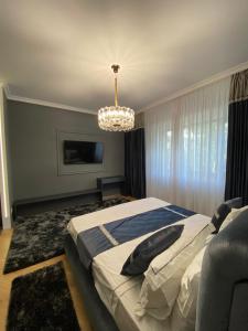a bedroom with a large bed and a chandelier at LY Studio Pipera in Voluntari +6 photos
