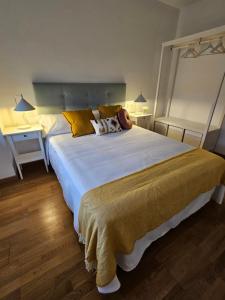 a bedroom with a large bed with yellow pillows at Casa Entre Viñas, jardin privado con piscina comunitaria in Uruñuela