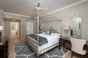 ein Schlafzimmer mit Himmelbett und Schreibtisch in der Unterkunft South Bay Beach Club #14 - 4 Bedroom 4 Bathroom Unit in George Town