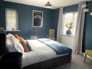 a bedroom with a large bed with blue walls at The Amazing Maisonette in Bideford