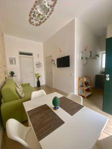 a living room with a table and a green couch at Casa Vacanze: Eureka in Ostuni