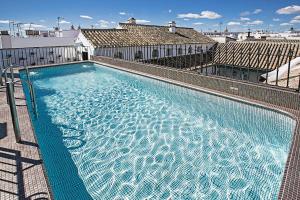 duży basen na dachu budynku w obiekcie Hospes Las Casas del Rey de Baeza, a Member of Design Hotels w Sewilli