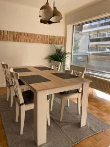 a wooden table and chairs in a room with a window at Hasselita in Hasselt