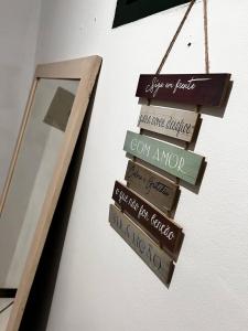 a group of signs hanging on a wall next to a mirror at O Portal hospedaria in Paraty