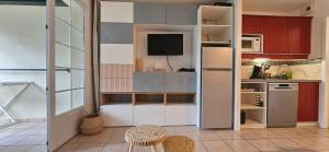 eine kleine Küche mit Kühlschrank und Mikrowelle in der Unterkunft Appartement cosy sous pinède lac de Biscarrosse rénové in Biscarrosse