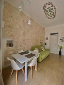 a living room with a table and a green couch at Casa Vacanze: Eureka in Ostuni
