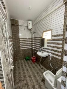 a bathroom with a sink and a toilet and a tub at Deqorum villas in Kumbakonam