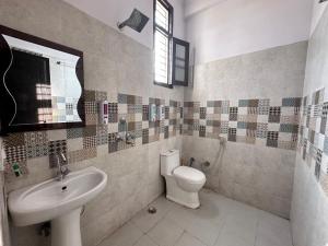 a bathroom with a toilet and a sink at Hotel Tulsi Inn in Haldwāni