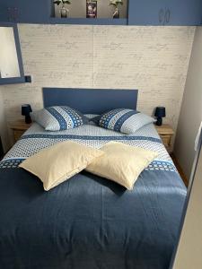 a blue bed with blue and white pillows on it at Chez Dom & Oli camping GINA PARK in Granges-Aumontzey +13 photos