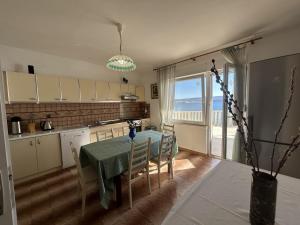 a kitchen and dining room with a table and a window at Azure Apartments By The Sea Near City Omiš in Omiš