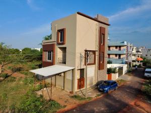 a building with a blue car parked in front of it at Deqorum villas in Kumbakonam