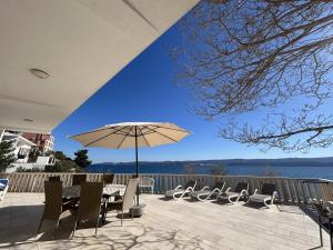 a patio with a table and chairs and an umbrella at Azure Apartments By The Sea Near City Omiš in Omiš