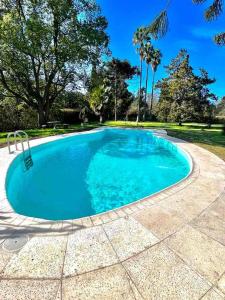 a large swimming pool with blue water at Casa de campo para hospeda y eventos in Villa Estanislao S. Zeballos