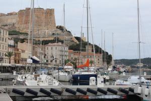 Ein Haufen Boote, die in einem Hafen mit einem Schloss angedockt sind. in der Unterkunft A LAVANDA Maison BONIFACIO in Bonifacio