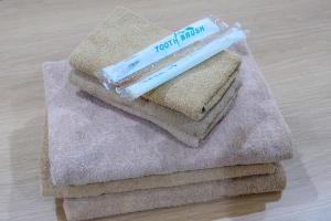 a pile of towels with a toothbrush on top of them at Y's INN NishiShinjuku 018T in Tokyo +47 photos