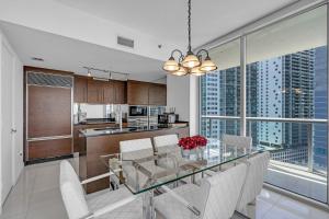 a dining room and kitchen with a glass table and chairs at Moderne 2 bed 2 bath Residence in Miami