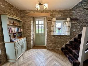 a room with stone walls and a staircase with a green door at Bilsdale Cottage in Helmsley +33 photos