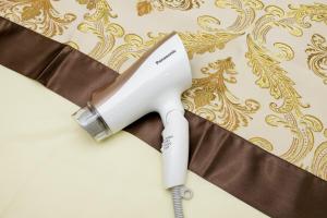 a white hair dryer sitting on top of a curtain at Y's INN NishiShinjuku 018T in Tokyo