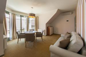 a living room with a couch and a table at Villa Oliva Boutique Rooms Zamárdi in Zamárdi