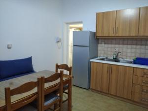 a small kitchen with a table and a refrigerator at Ios Village View in Ios Chora +25 photos
