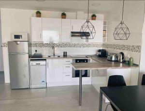 a kitchen with white cabinets and a refrigerator at CAPISTRANO BREEZE - Luxury Coastal Apartment in Capistrano Village, Nerja in Nerja
